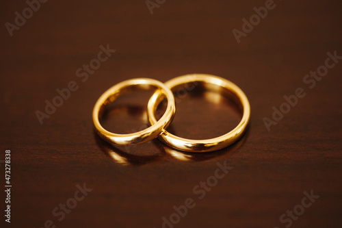 White gold wedding rings. Closeup wedding jewelry. Metal rings on wooden table. Getting ready to get married. Symbol of being together.