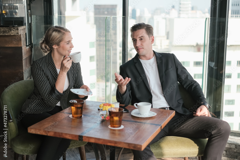 Two businessman and businesswoman couple meeting in co working space or office Two businessman and businesswoman couple meeting in co working space or office