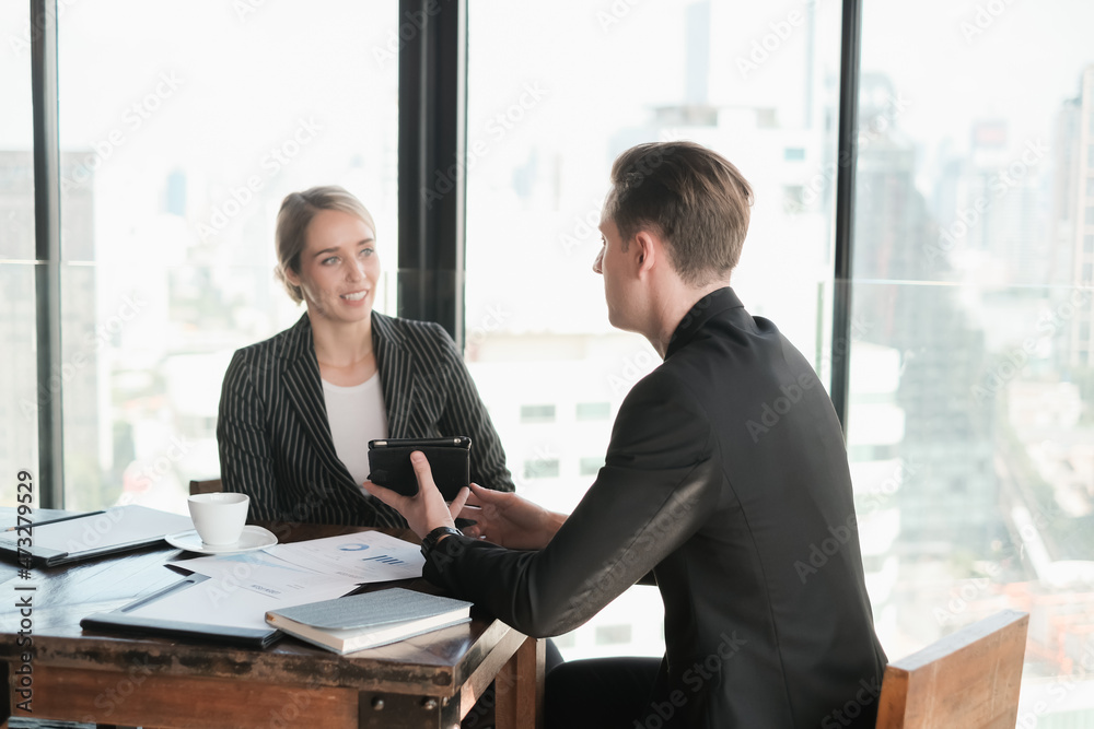 Two businessman and businesswoman couple meeting in co working space or office Two businessman and businesswoman couple meeting in co working space or office