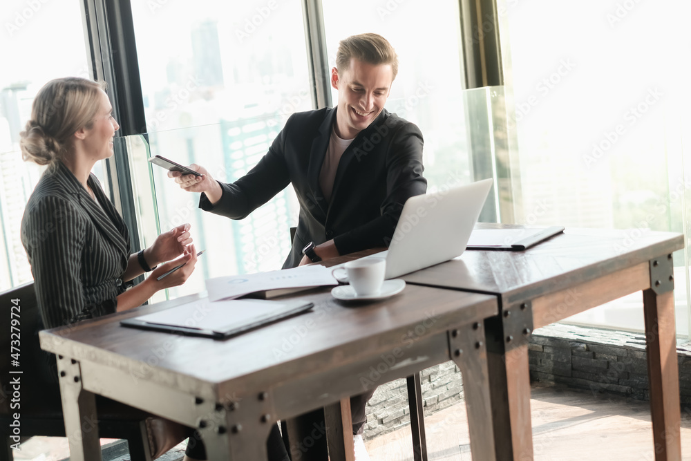 Two businessman and businesswoman couple meeting in co working space or office Two businessman and businesswoman couple meeting in co working space or office