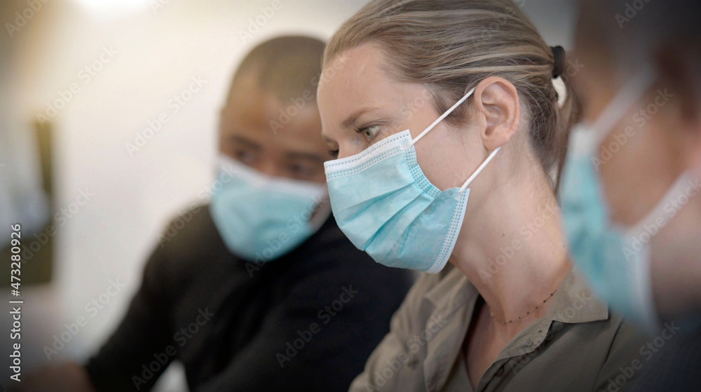 team working in an office wearing covid-19 pandemic masks