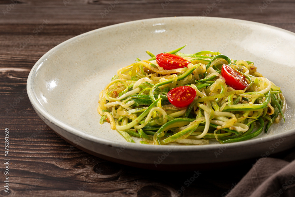 Zucchini spaghetti with tomatoes in garlic and oil. Zucchini spaghetti with tomatoes in garlic and oil.