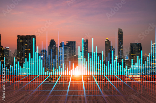 Rooftop with wooden terrace  Bangkok sunset skyline. Forecasting and business modeling of financial markets hologram digital charts. City downtown. Double exposure.