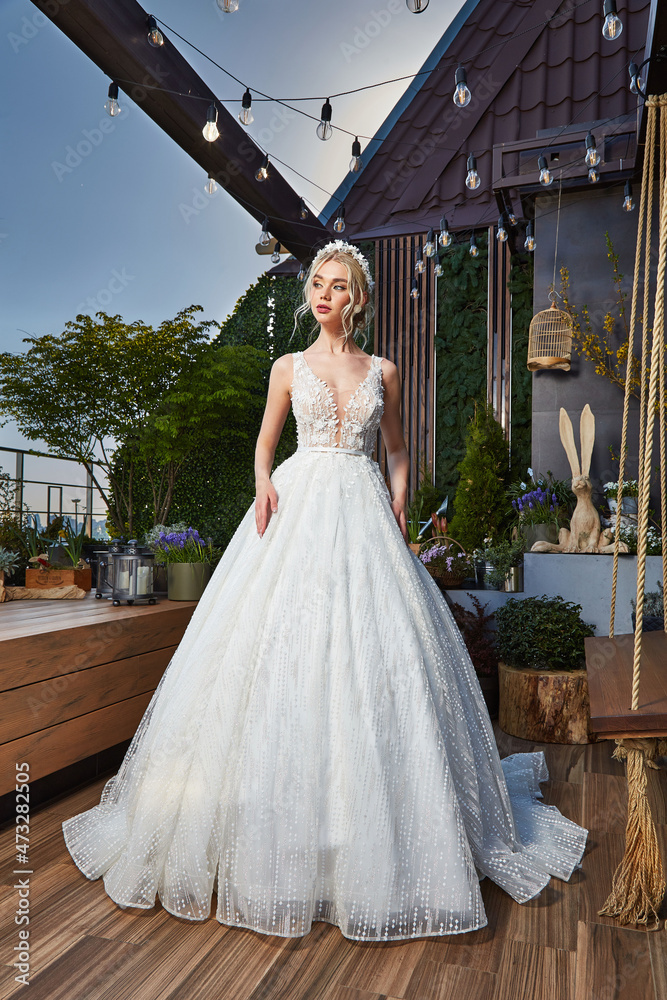 Fototapeta premium Sexy beautiful blonde woman pretty bride wedding big day marriage ceremony in summer garden wearing long silk and lace white dress bright makeup hairstyle pure love interior.