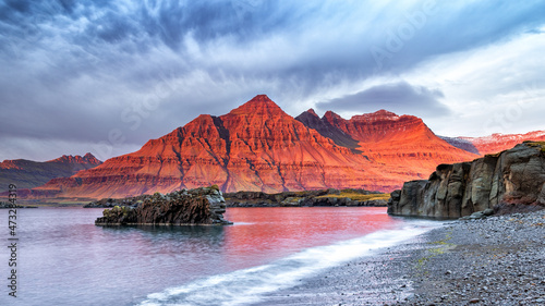 The Bulandstindur, or Pyramid mountain in Iceland. For a few moments, the rock glows red  at sunrise photo