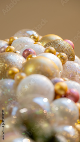 Christmas celebration concept. Bottom view close up photo of beautifully decorated yellow and white baubles and isolated on gold background with copyspace