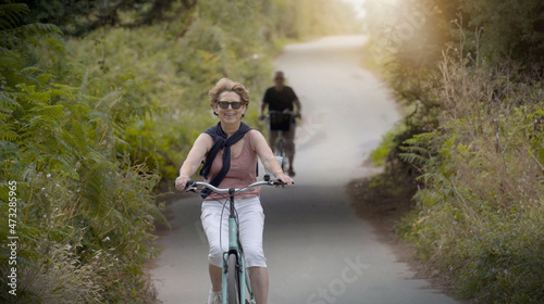 Photography senior woman cycling in summer