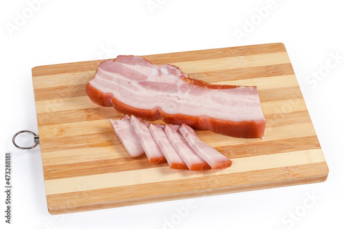 Partly sliced boiled smoked pork belly on wooden cutting board