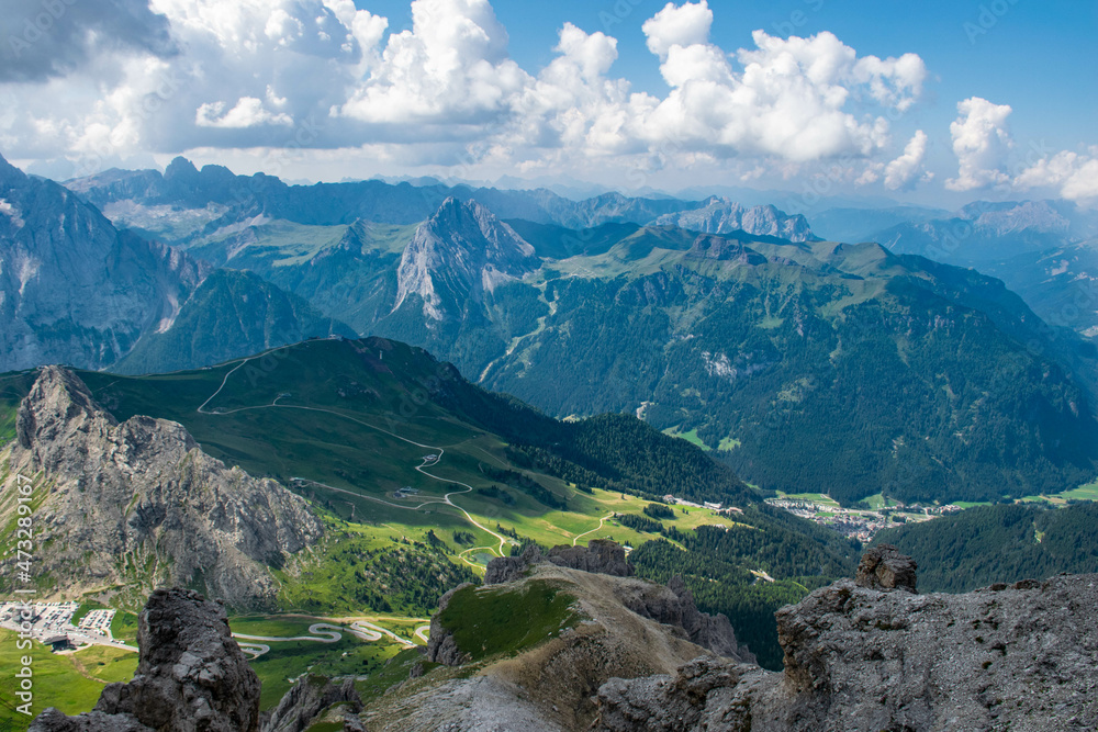 Dolomites, 2017, panoramic view from the top of the Marmolada Passo Fedaia to the green valley, mountains in the distance and the cable car