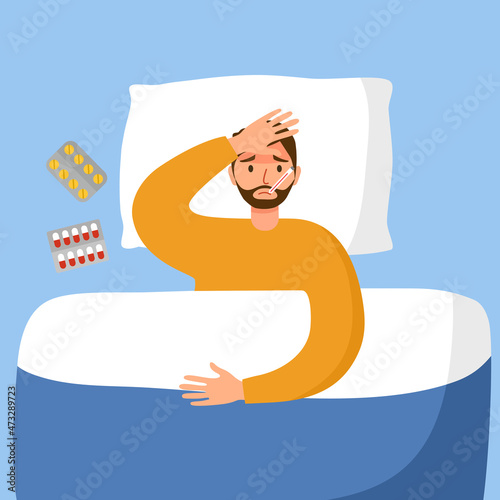 Man suffering from flu in bed under blanket. Guy has fever and take thermometer in mouth with medicine on bed. Flu or cold allergy symptom.