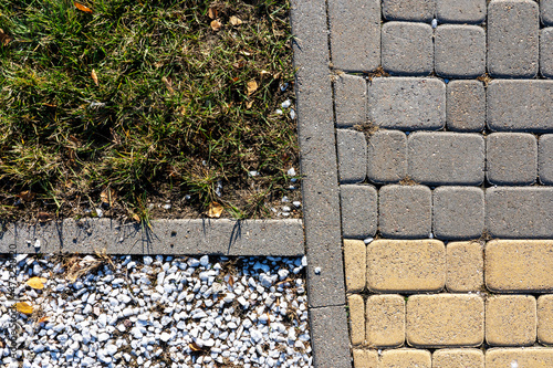 Fototapeta Naklejka Na Ścianę i Meble -  Photo of asphalt, small white stones and green grass on the street in the city. Abstraction