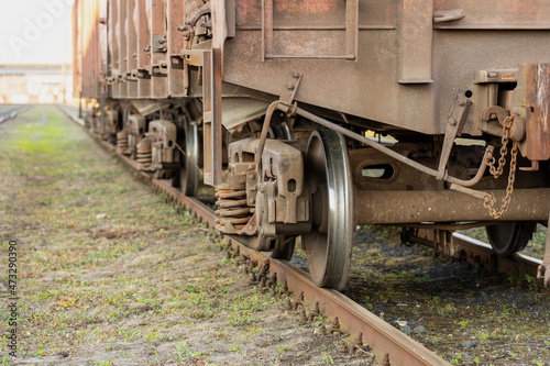 Photo of a train that travels by rail against a background of green grass. Wheels, rails and sleepers