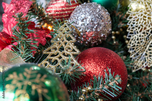 Photo of silver and red shiny Christmas balls on a green Christmas tree. New Year