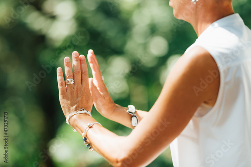 Middle Aged Woman Practicing Tai Chi Chuan in the Park. Close Up On Hands Position photo