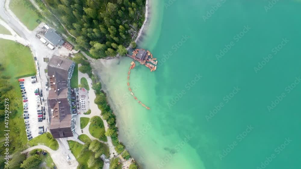 Aerial view of lake Braies in Dolomites mountains, water reflections. Boats floating on water surface of lago di Braies. European Alps. Famous landmark, travel destination. Italy, Europe. 