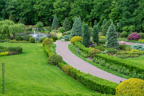 The wall consists of a green hedge. Geometric bush landscape design