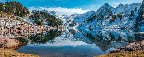 Obraz na płótnie Reflection of the snowy mountains in the beautiful Baciver lake in the Pyrenees mountains of Val d'Aran (Aran Valley), Lleida, Catalonia, Spain w salonie