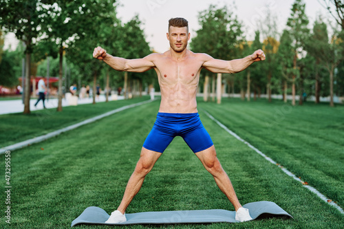 sporty muscular man goes in for sports in the park workout motivation