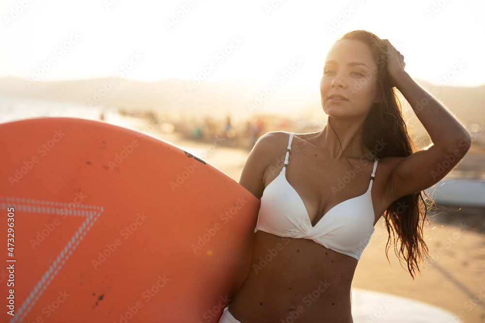 Fototapeta premium Young happy woman with surfboard. Hot sexy girl preparing for the surf. Beautiful woman enjoy in sunny day..