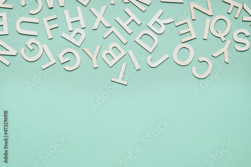 Canvas Print jumble of wooden letters falling down on blue paper background