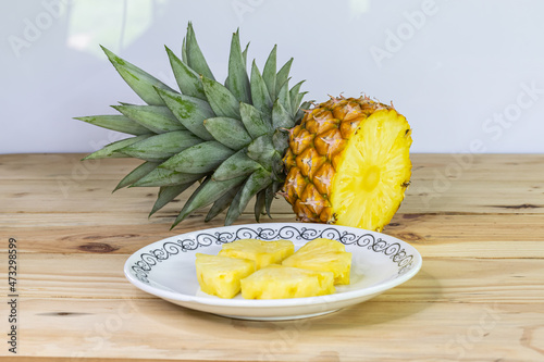 halved and sliced pineapple, on wooden table, close up, sweet and sour fruit, nutritious and high in vitamins