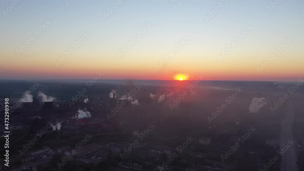 Drone shot of industrial zone with thick smog and burning fossil fuels. Shooting at sunrise. Air pollution . The silhouette of the blast furnace Drone shot of industrial zone with thick smog and burning fossil fuels. Shooting at sunrise. Air pollution . The silhouette of the blast furnace