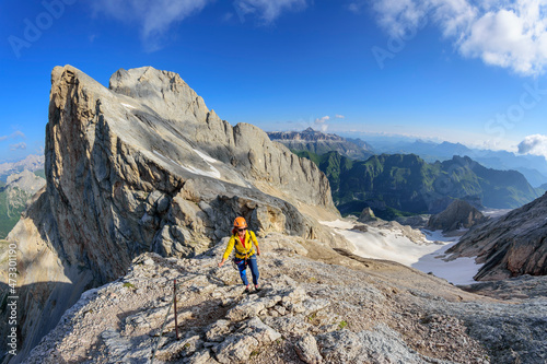 Female climber ascending ridge of Marmolada mountain photo