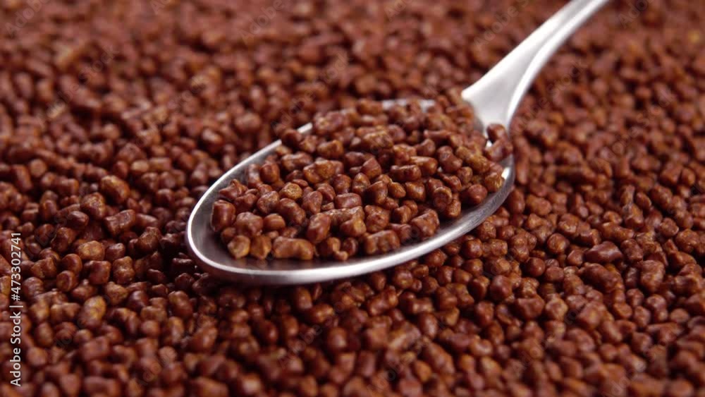 Full teaspoon of buckwheat tea granules. Macro. Rotation. Traditional Asian drink ingredient Full teaspoon of buckwheat tea granules. Macro. Rotation. Traditional Asian drink ingredient