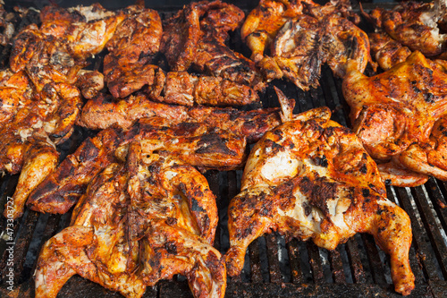 Chicken pieces cooking on a barbeque grill photo