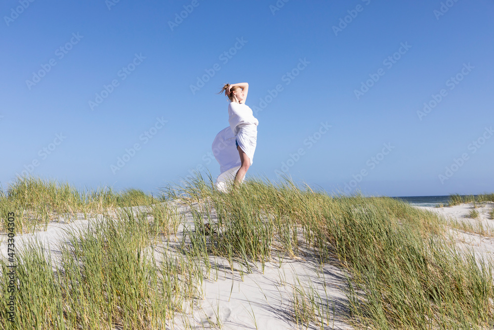 Teenage girl wrapped in white, Grotto Beach, Hermanus, Western Cape, South Africa. Teenage girl wrapped in white, Grotto Beach, Hermanus, Western Cape, South Africa.