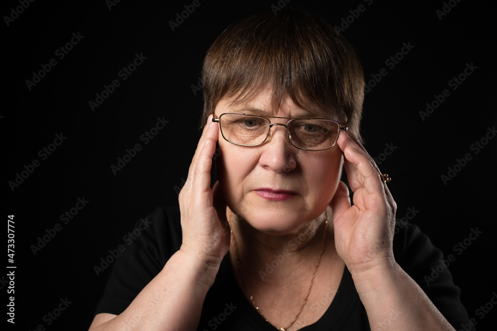 Grandma holds her head with her hands as if she has a headache.