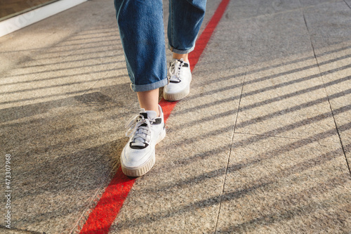 Woman walking on red marking at footpath photo