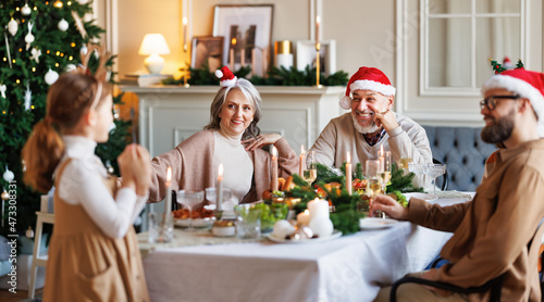 Tableau sur toile Little girl recites Christmas poem to multi-generation family during Xmas dinner