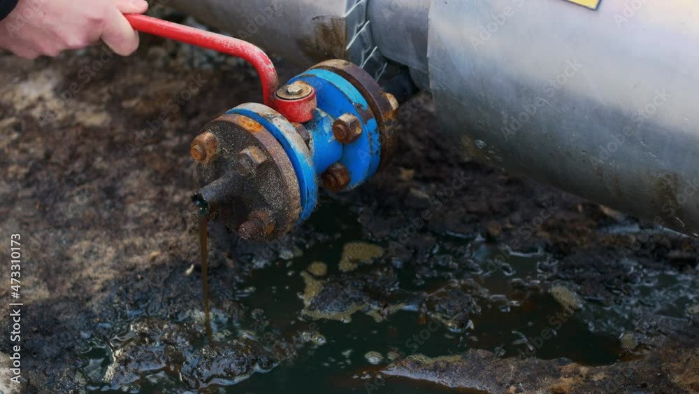 Oil flows from the pipe to the ground, oil leakage with soil pollution