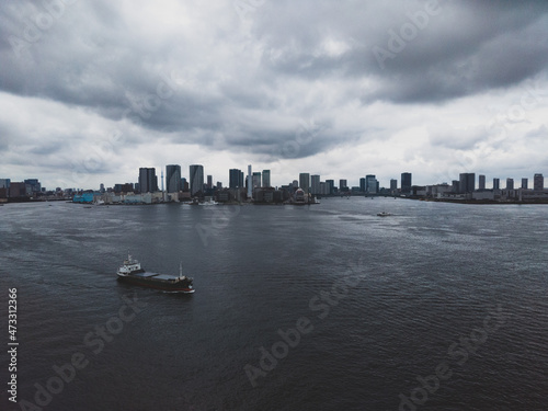 暗雲が立ち込める東京湾揚エリアと貨物船