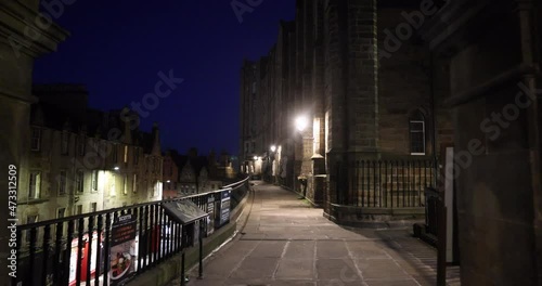 Edinburgh , East Lothian, circa 2021, Empty Victoria Street on a quiet night with traditional shops, the street lights cast gloomy shadows on the buildings lining the dark street