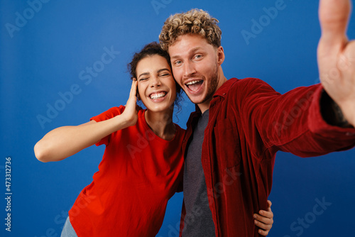 Young white couple smiling while taking selfie photo