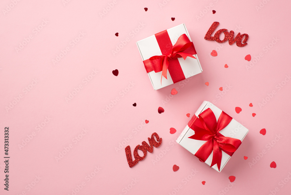 Top view photo of valentine's day decorations two white gift boxes with red ribbon bows inscriptions love and heart shaped confetti on isolated pastel pink background with copyspace Top view photo of valentine's day decorations two white gift boxes with red ribbon bows inscriptions love and heart shaped confetti on isolated pastel pink background with copyspace