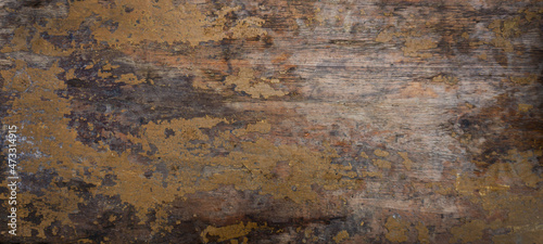 Wooden wall with old crumbling paint. The texture of the old painted board. The orange paint has cracked with age.
