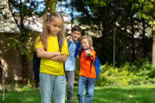 Upset school child on outdoor background