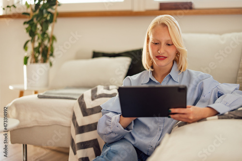 Focused caucasian blonde woman, scrolling through a gallery of photos.