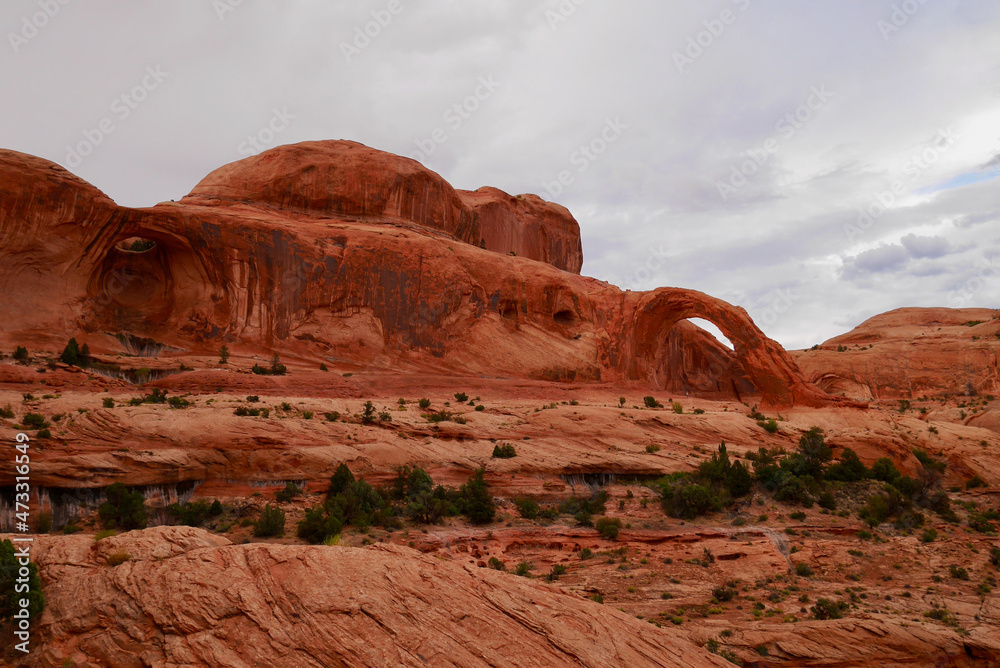 Corona Arch in the surroundings of Moab. Typical Utah landscape at sunset, red rock formations. Corona Arch in the surroundings of Moab. Typical Utah landscape at sunset, red rock formations.