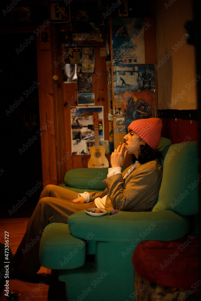 stylish young boy smoking sitting on the sofa stylish young boy smoking sitting on the sofa