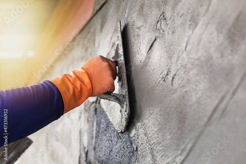 Concrete plasterers to create industrial workers background walls with plastering tools. photo