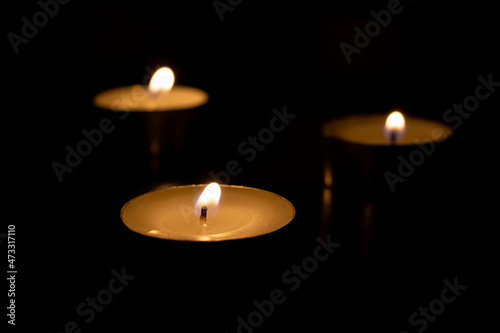 Three burning candles on the table closeup