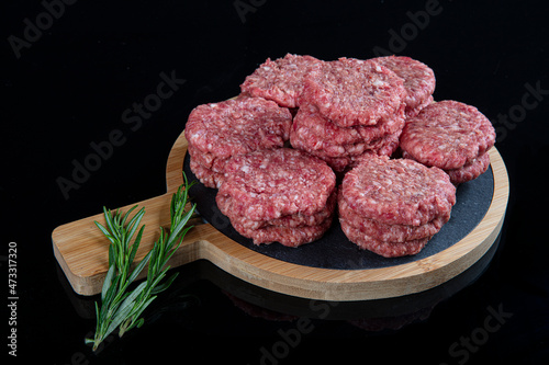 Raw beef meatballs made with various homemade spicy, beef kofta kofta raw, on black ground. photo