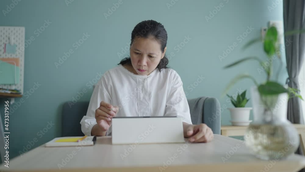 Graphic designer asian woman drawing on tablet using digital pen at home Graphic designer asian woman drawing on tablet using digital pen at home