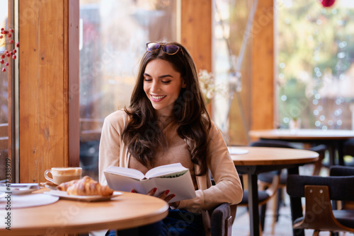 Beautiful woman sitting in the cafe and reading book