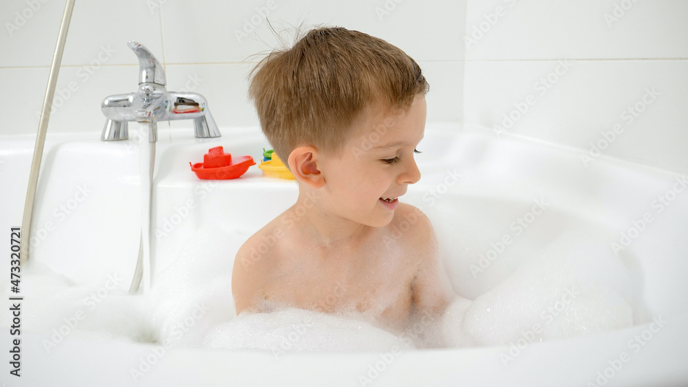 Portrait of little boy washing in bath full of soap suds and foam Portrait of little boy washing in bath full of soap suds and foam