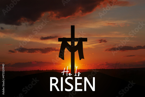 Saviour's cross on dramatic sunrise scene, with text He is risen